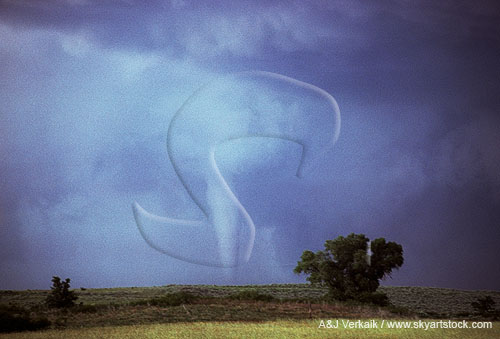 Slender, white cone tornado with sky brightened by clear slot