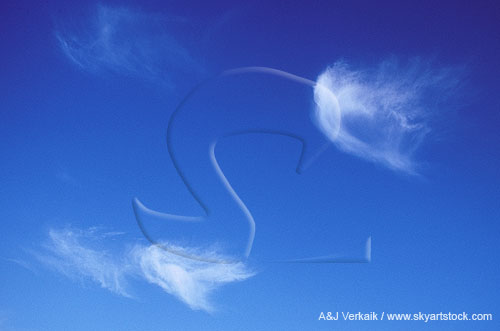Cloud wisps are dancing with joy in a pure blue sky