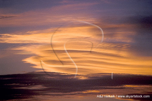A flight of satin smooth cloud layers in an enchanted gold and pink sunset sky.