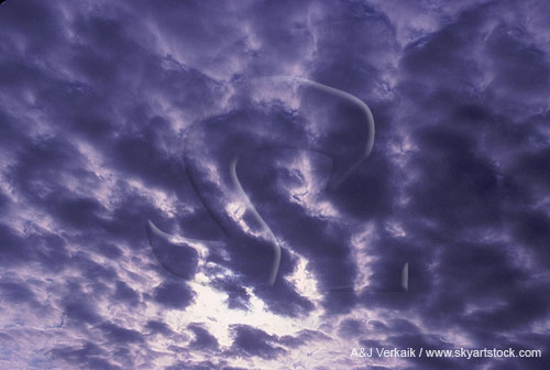 Cloud billows fan out across a brooding sky
