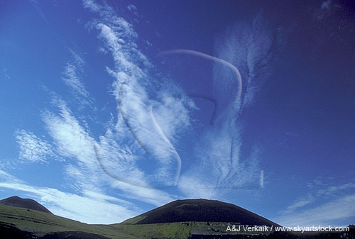 Clouds fan out joyously over a pristine mountain landscape