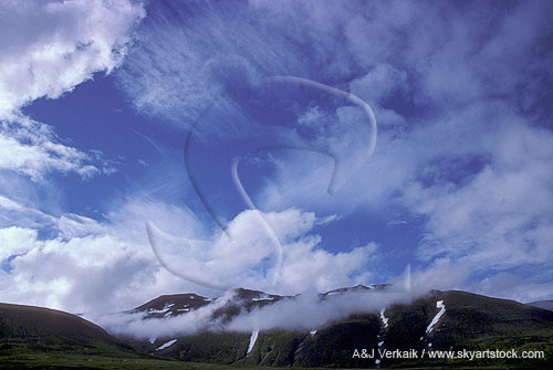 Many different types of clouds at all levels in a mountain skyscape