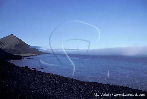 A distant bank of advection fog or sea fog off a lonely shoreline