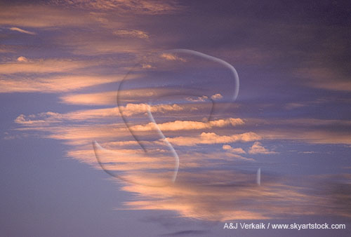 Slender cloud strips glow with brilliant sunset light