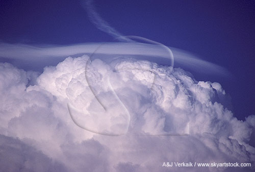 A dense, detached Pileus cap cloud above a storm