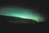 An eerie sweeping arc of intense green northern lights.