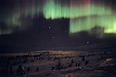 Curtains of northern lights spread mystery across an arctic landscape