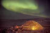 Northern Lights over an arctic igloo glowing from within