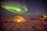 A swirling patch of Aurora and igloos with fire light inside