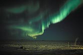 Whirling curtain of Aurora Borealis over arctic snow