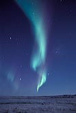 Spiraling green and purple northern lights in an arctic sky