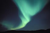 A green fan of Aurora Borealis over an arctic ridge