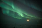 Gentle sweeps of northern lights with a nearly full moon