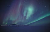 Colorful northern lights (Aurora Borealis) in an arctic starry night