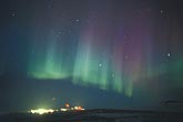 A magical curtain of northern lights over a starlit arctic town