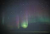 Colorful curtains of Aurora Borealis with a bright green highlight