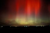 Awesome brilliant red Aurora Borealis over farm lights