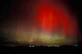 Patches of amazing red and green northern lights over farm lights