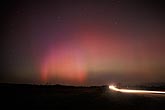 Purple, red and green Aurora Borealis over a country road