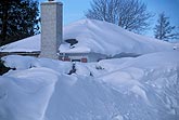 A house hidden by heavy buildup of snowfall on the ground