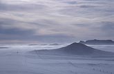 Blowing snow veils desolate hills