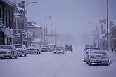 Heavy falling snow on a city street with cars driving