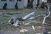 Twisted metal, branches and a tricycle damaged by a tornado