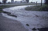 Flood waters in overflowing roadside ditch
