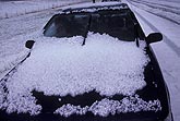 A pile of hail on a car on a hail-covered highway