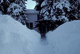 House hidden behind high snow after a winter storm
