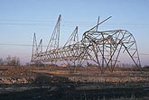 Mangled steel tower in a power corridor after a tornado strikes.
