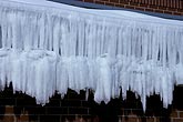 Tiers of icicles hang from the eaves of a building