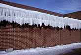 Tiers of icicles in a solid rim hang from a building