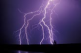 A tangle of multiple bolt lightning strikes tears through the night sky