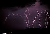 Multiple lightning bolts strike in a dark foreboding sky