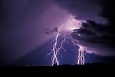Cloud-to-ground lightning bolts with a sweeping rain curtain