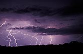 Finely etched lightning in a glowing purple sky