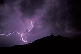 A single knotted lightning bolt behind a silhouetted mountain