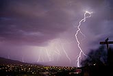 Ghostly multiple lightning strikes over city lights