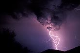 A single, erratically tangled lightning bolt strikes in the mountains