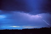 Delicate fingers of lightning in a gentle purple and blue twilight sky