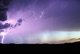 Spangles and bolts of lightning etched against a sunset sky
