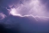 A brilliant horizontal lightning branch explodes across the sky