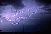 Fingers of spider lightning spread thin ribbons across the stormy sky