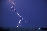 A single bright lightning bolt strikes fear by a farmhouse
