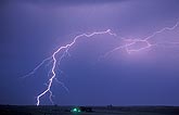 A single lightning bolt passes by in pale twilight