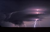 Supercell with lightning at night with a ragged wall cloud
