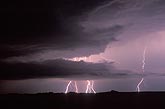 Distant lightning bolts light up storm clouds