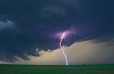 A brilliant lightning bolt in an eerie ochre-yellow twilight sky