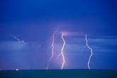 Three lightning bolts glow pink against the daytime sky